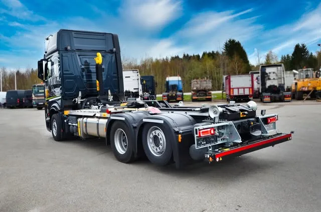 Dunkle Zugmaschine mit Abrollkipper-Fahrgestell auf dem Hof